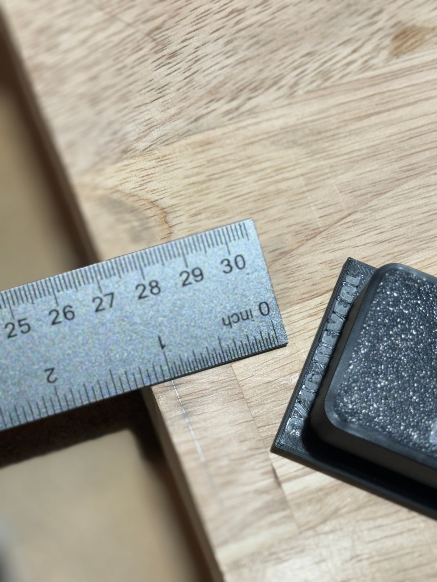 In this photo, a user is measuring a 3/16 inch reveal using the TrimMate Pro by FishyFabsPNW. The 3/16 inch reveal plate is securely attached to the tool with four 6mm M3 screws. The embedded magnet allows the tool to double as a stud finder, ensuring precise and efficient carpentry work.